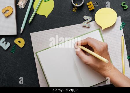 Zurück zum Schulkonzept. Schulbedarf und Bürobedarf auf dem Bürotisch. Flach liegend mit Kopierplatz. Minimalistischer cremiger Hintergrund. Stockfoto