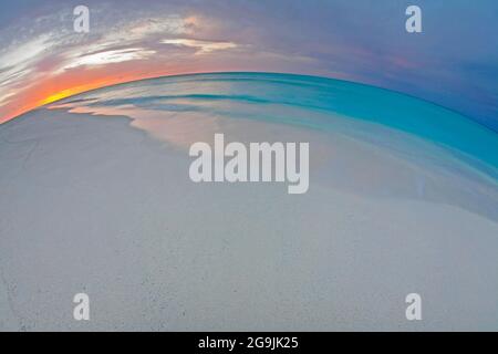 Sonnenuntergang über Midway Atoll Beach und Lagune auf Sand Island im Papahanaumokuakea Marine National Monument, mit geschwungenem Horizont Stockfoto