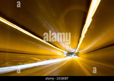 Fahren In Der Stadt. Leichter Regen. Langzeitbelichtung. Blick durch die Windschutzscheibe während der Nachtfahrt. Langzeitbelichtung. Künstlerisch, abstrakt. Stockfoto