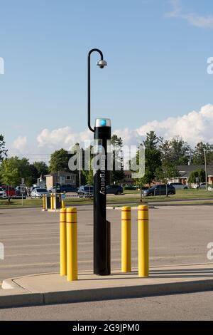Blaue Notrufanlage mit oben angebrachter Kamera, um die Sicherheit auf einem Krankenhausparkplatz zu gewährleisten. Stockfoto