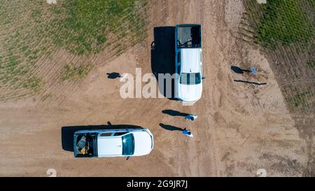 Luftaufnahme des 4x4 Pickup-LKW, der durch Weizenanbau-Feld mit Silosäcken auf der Straße fährt. Argentinien Stockfoto