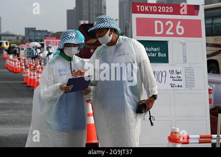 Tokio, Japan. Juli 2021. Im Regen stehen Freiwillige in Regenmänteln an der Bushaltestelle. Quelle: Swen Pförtner/dpa/Alamy Live News Stockfoto