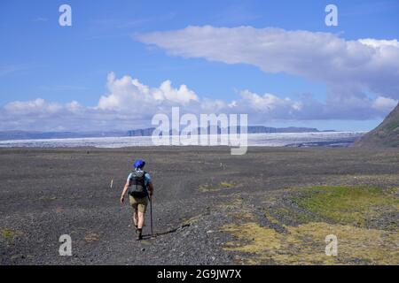 Frau beim Wandern auf einer breiten Kiesfläche in Morsardalur, Skaftafell NP, Austurland, Island Stockfoto