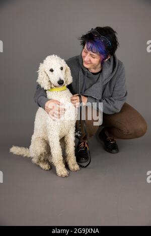 Frau mit weißem Königspudel, Studioaufnahme, Deutschland Stockfoto