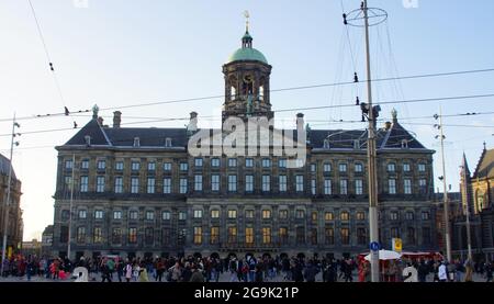 AMSTERDAM, NIEDERLANDE - 27. Nov 2011: Eine wunderschöne Aussicht auf den Dam-Platz in Amsterdam, Niederlande, mit einer Menge Touristen, die sich unter einem Klau versammelten Stockfoto