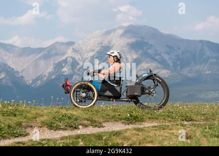 Teilnehmer an adaptiven Sportarten, die mit einem Bowhead Reach-Fahrrad für adaptive Mobilität arbeiten, Canmore Nordic Centre, Canmore, Alberta, Kanada. Stockfoto