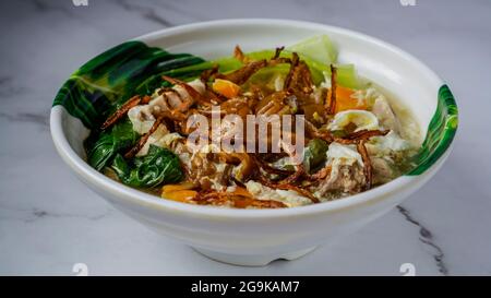 Flache Nudeln in Egg Gravy (Wan Tan Hor) mit Hühnerstückchen und Fischbällchen gekocht. Garniert mit gebratenen Zwiebeln. Eine chinesische Küche serviert in Southeast As Stockfoto