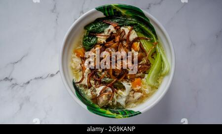 Flache Nudeln in Egg Gravy (Wan Tan Hor) mit Hühnerstückchen und Fischbällchen gekocht. Garniert mit gebratenen Zwiebeln. Eine chinesische Küche serviert in Southeast As Stockfoto