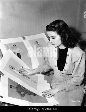 JOAN BENNETT am Set offen studiert Kostümdesigns von TRAVIS BANTON für SECRET BEYOND THE DOOR 1947 Regisseur FRITZ LANG Walter Wanger Productions / Universal Picturs Stockfoto