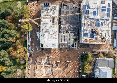 Luftaufnahme von oben auf der Baustelle mit Baumaschinen und Arbeitskränen Stockfoto