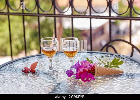 Entspannende Sommercocktails mit rosa Blüten von Bougainvillea auf einem Glastisch. Erfrischungskonzept. Sommer grelle surreale Blumen und hausgemachte Getränke. Speicherplatz kopieren. Hochwertige Fotos Stockfoto