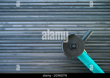 Winkelschleifer auf Stahl. Hintergrund aus Stahlrohren. Geformte Metallrohre. Mehrere Metallrohre liegen nebeneinander. Linien durch Rohre erstellt. Einen Zaun machen Stockfoto