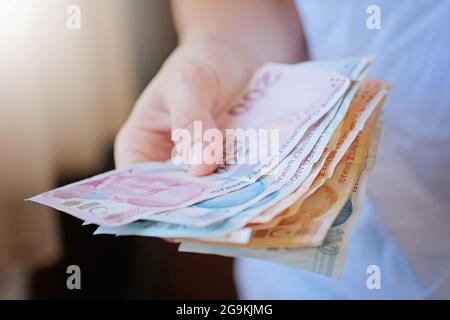Türkische Lira-Banknoten in Frauenhand. Die Papierwährung der Türkei. Die aktuellen türkischen Lira werden von der Zentralbank der Republik Türkei ausgegeben. F Stockfoto