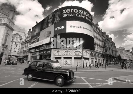 London, England - 27. Mai 2013: Ein schwarzes Taxi überquert die ikonischen Videowerbung-Werbetafeln des Piccadilly Circus, einem berühmten öffentlichen Raum in London Stockfoto