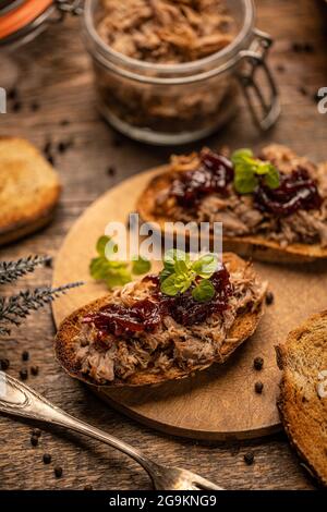 Gezogene Ente mit karamellisierten Zwiebeln auf rustikalem Hintergrund Stockfoto