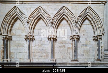 Dekorative spitze gotische Bögen an der Wand des Nordschiffs in der mittelalterlichen Kathedrale von Lincoln, England. Stockfoto