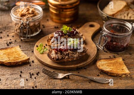 Gezogene Ente mit karamellisierten Zwiebeln auf rustikalem Hintergrund Stockfoto