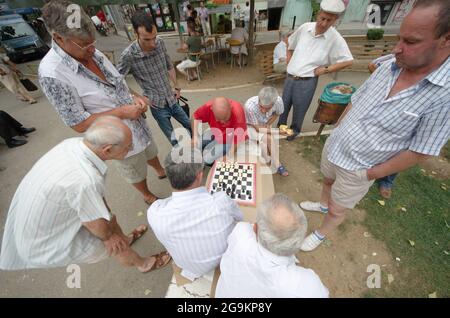 Tirana, Albanien - 23. Juli 2012: Zwei Männer mittleren Alters spielen das Schachspiel, umgeben von anderen Menschen. Der Park 1. Mai (oder die Kajupi) in Tirana ist c Stockfoto
