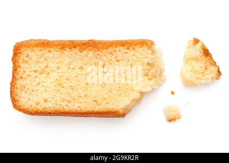 Teilweise gefressene Scheibe von einfachem Biskuitkuchen, flach isoliert auf Weiß liegend. Mit Krümel. Draufsicht. Stockfoto