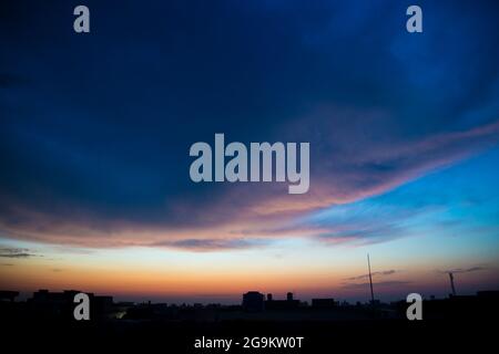 Sonnenaufgang dramatischer blauer Himmel mit orangefarbenen Sonnenstrahlen, die durch die Wolken brechen. Natur Hintergrund. Hope-Konzept Stockfoto