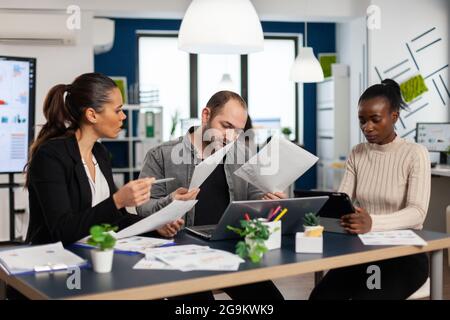 Nervöser Geschäftsmann, der im Coworking Space streikt, am Arbeitsplatz Konflikte hat und beschuldigt, schlechte Fehler bei der Inkompetenz der Arbeit begangen zu haben. Rügen erfolgloser Ergebnisse und Rivalität Konzept. Stockfoto