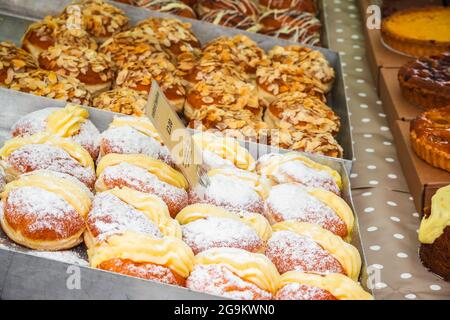 Eine Auswahl an berlinern, deutschen Donuts, wird auf dem Broadway Market, einem Straßenmarkt in Hackney, East London, ausgestellt Stockfoto