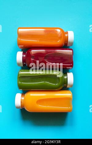 Frische Säfte oder Cocktails von Obst und Gemüse in Flaschen auf blauem Hintergrund. Das Konzept einer gesunden Ernährung oder Entgiftung. Flach liegend, Draufsicht. Stockfoto