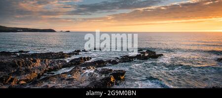 Ein Panoramabild eines spektakulären Sonnenuntergangs über der Fistral Bay an der Küste von Newquay in Cornwall. Stockfoto