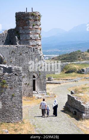 die muslimische Familie geht durch die Ruinen des Minaretts, das von den Türken der St. Stephens Kirche hinzugefügt wurde, und verwandelt es in eine Moschee im Schloss Rozafa, Shko Stockfoto