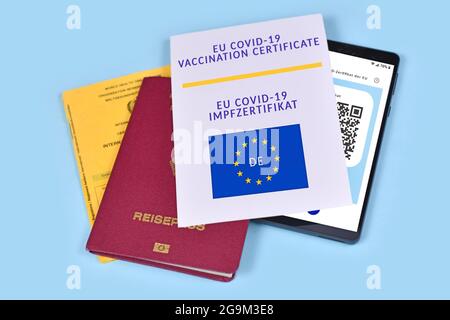 EU-Impfpass COVID-19 auf Papier und digital auf Mobiltelefon und Impfpass Stockfoto