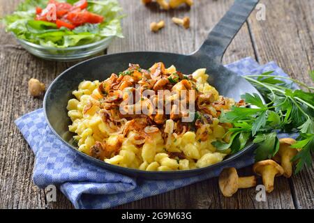 Vegetarischer deutscher Spätzle mit gebratenen Pfifferlingen und Zwiebeln in einer Pfanne Stockfoto