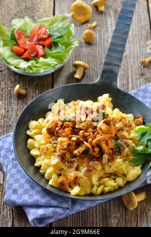 Vegetarischer deutscher Spätzle mit gebratenen Pfifferlingen und Zwiebeln in einer Pfanne Stockfoto