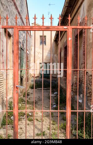 Verlassene Haus mit rotem schmiedeeisernem Tor im Dorf los Alcazares in Murcia, Spanien Stockfoto