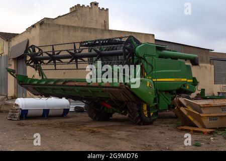 Vilafranca de Bonany, Spanien; juni 05 2021: Grüner mechanischer Erntemaschinen, der bei Sonnenuntergang neben einem ländlichen Bauernhof im Landesinneren der Insel Mallorca geparkt ist Stockfoto