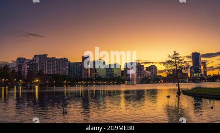 Farbenfroher Sonnenuntergang über dem Lake Eola und der Skyline der Stadt in Orlando, Florida Stockfoto