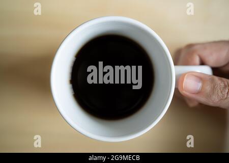 Schwarzer Kaffee in einer weißen Tasse, von oben aufgenommen Stockfoto