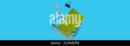 Schreibwaren Bürobedarf mit Einkaufswagen schweben auf blauem Hintergrund Stockfoto