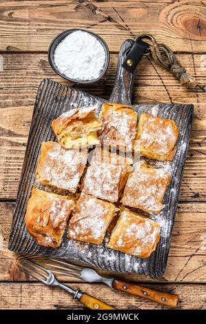 Griechisches Gebäck Bougatsa mit Phyllo-Teig und Grießpudding Sahne. Holzhintergrund. Draufsicht Stockfoto