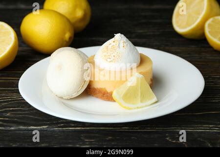 Teller mit Cupcake und Makronen und Zitronen auf Holztisch Stockfoto