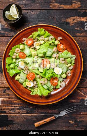 Meeresfrüchte Avocado, Garnelen, Garnelen Salat. Dunkler Holzhintergrund. Draufsicht Stockfoto