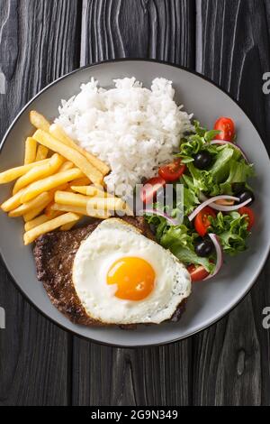 Bitoque ist ein traditionelles portugiesisches Gericht, das aus gegrilltem Rindersteak mit Pommes Frites, Reis, verschiedenen Salaten und einem Ei in der Nähe besteht Stockfoto