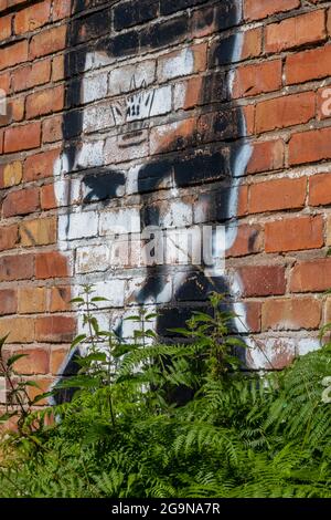 Das Gesicht von Mans wurde in einem roten Backsteingebäude im Großraum Manchester, großbritannien, auf eine Wand im Street-Art-Graffiti-Stil gesprüht. Stockfoto