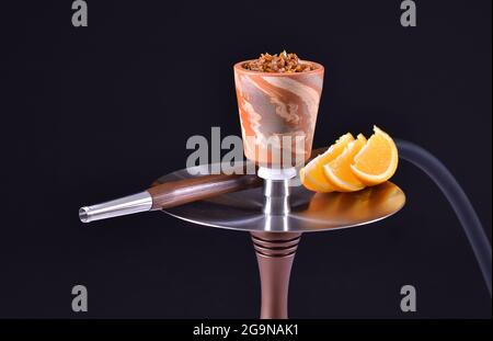 Shisha-Schale mit Tabak auf schwarzem Hintergrund mit Orange Stockfoto