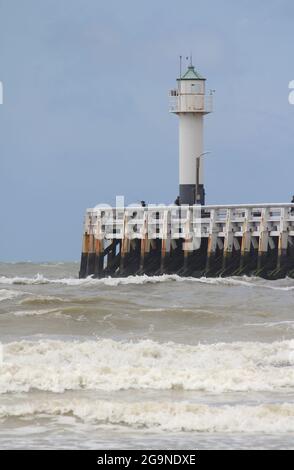 Leuchtturm am Ende des Nieuwpoort Pier (Westerstaketsel) an einem windigen Sommertag in Nieuwpoort-Bad, Westflandern, Belgien Stockfoto