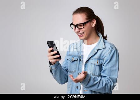 Junger Mann mit Brille und Smartphone Stockfoto