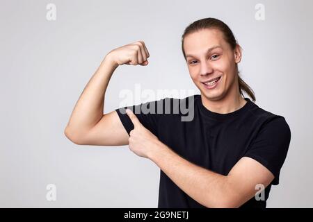 Junge Fitness starker Mann zeigen Bizepsmuskeln auf der Hand Stockfoto