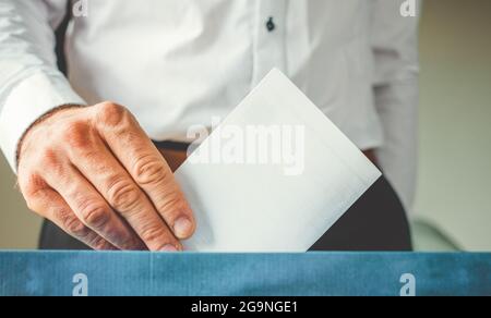 Männliche Hand, die die Stimme in die Abstimmung einbringt Stockfoto