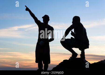 Salvador, Bahia, Brasilien - 25. April 2021:Silhouette der Fischer auf den Felsen des Rio Vermelho Strandes in Salvador, Bahia, Stockfoto