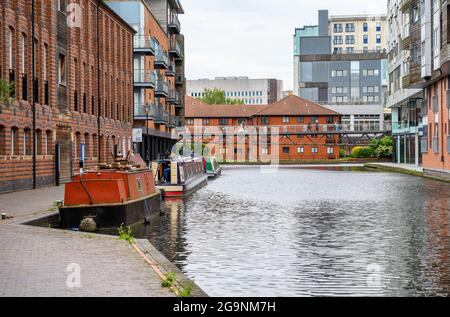 Schmale Boote, die am Schleppturm an der Birmingham Canal Old Line gegenüber vom Cube und dem Mailbox Complex in Birmingham City, England, festgemacht sind. Stockfoto