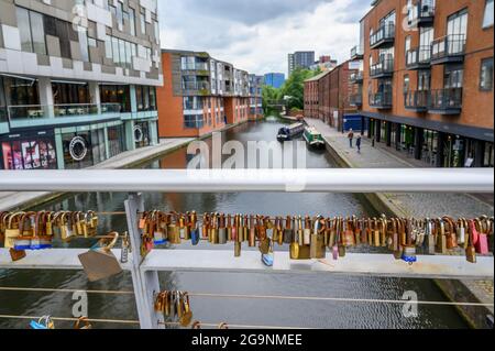 Vorhängeschlösser, die an Geländern auf der Love Lock Bridge über den Birmingham Canal Old Line von The Cube und der Mailbox in Birmingham, England, verschlossen sind. Stockfoto